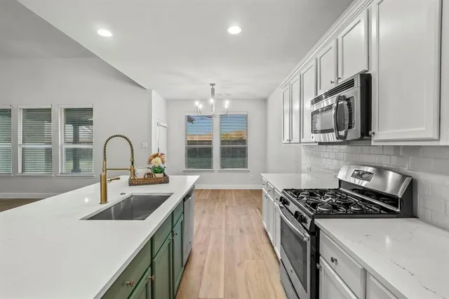 a kitchen with stainless steel appliances granite countertop a stove and a sink