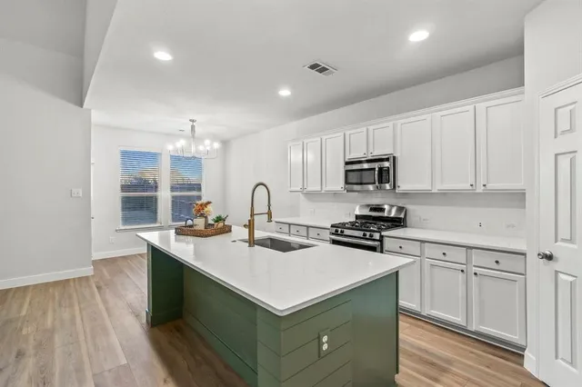 a kitchen with a sink stove and cabinets