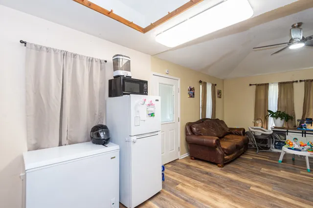 a living room with furniture a refrigerator and a dresser