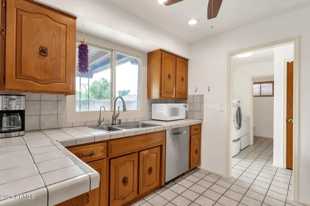 a kitchen with a refrigerator a sink and dishwasher a oven with white cabinets