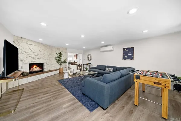 a living room with furniture a flat screen tv and a fireplace