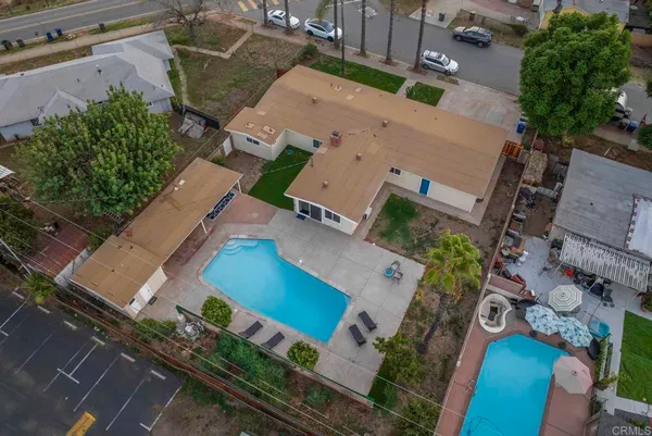 an aerial view of a house with yard and seating space