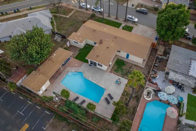 an aerial view of a house with yard and seating space