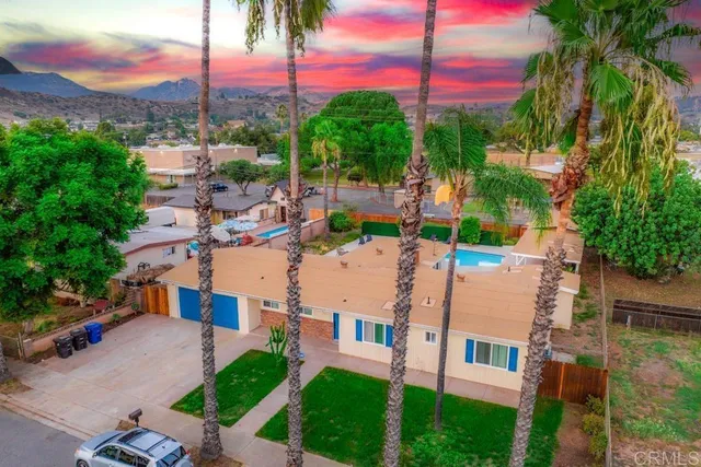 a front view of a house with a yard and potted plants