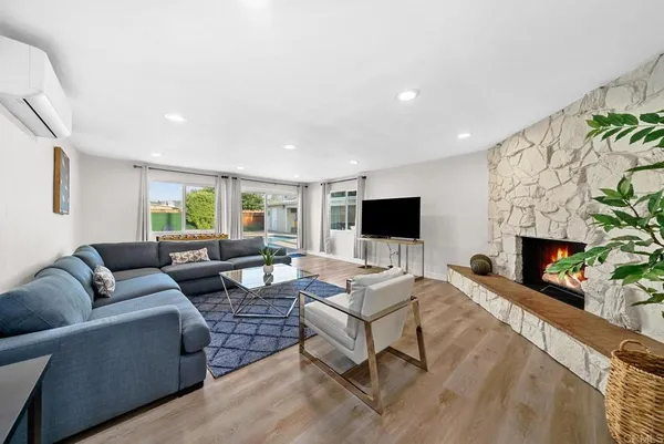 a living room with furniture a fireplace and a flat screen tv