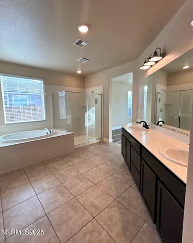 a large bathroom with a large mirror vanity and a shower