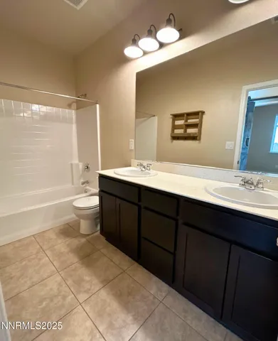 a bathroom with a sink a toilet and a large mirror