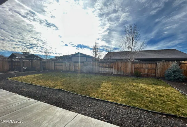 a view of a backyard with wooden fence
