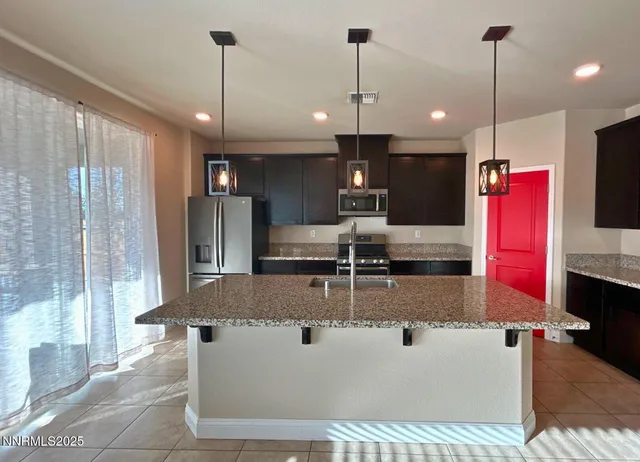 a view of a kitchen with kitchen island a counter top space appliances and a chandelier