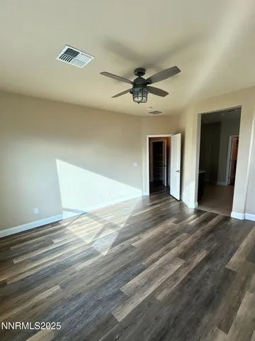 a view of an empty room with a ceiling fan