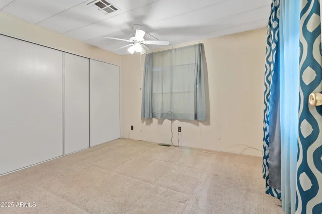 a view of a livingroom with a chandelier fan and a bathroom