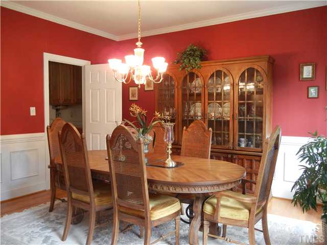 Formal dining room. Wainescotting , hardwood flooring and crown molding.