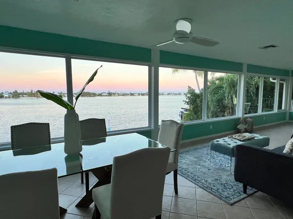 a living room with patio furniture and a floor to ceiling window