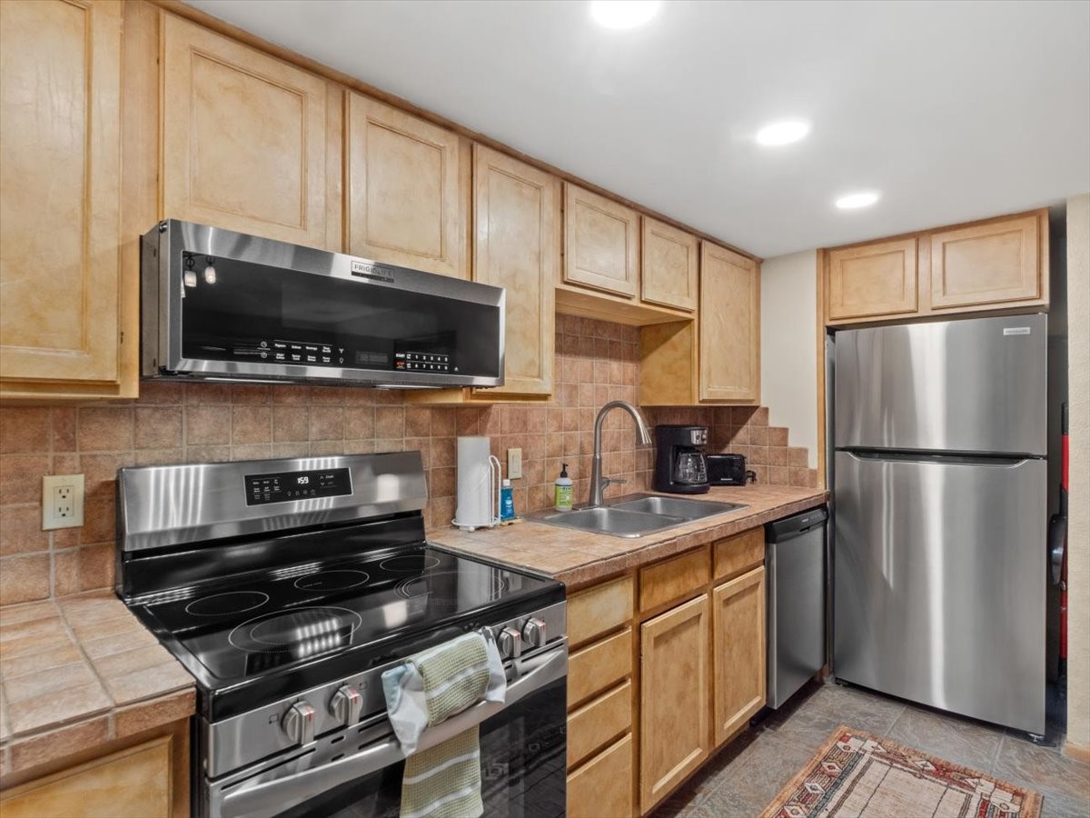 108 Guller Road, Unit B4 Frisco, CO 80443 - Photo 8 of 21 Kitchen featuring appliances with stainless steel finishes, backsplash, light brown cabinetry, and recessed lighting