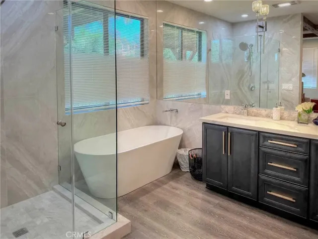 a spacious bathroom with a tub sink shower and mirror