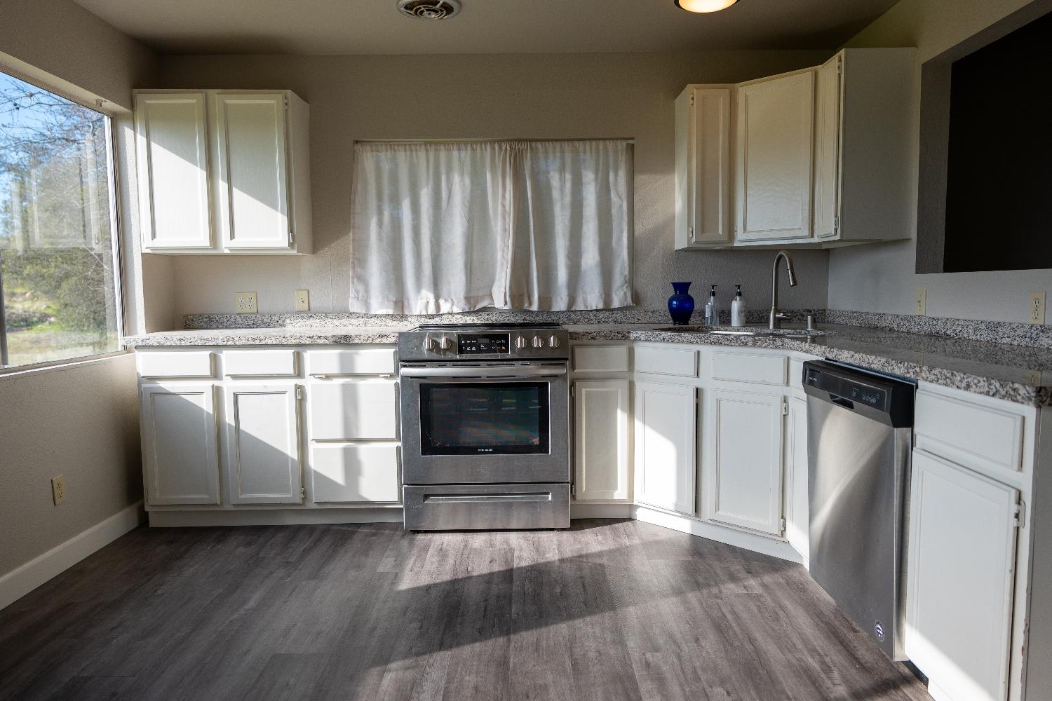 42560 Ranger Cir Way Coarsegold, CA 93614 - Photo 15 of 44 a kitchen with a stove a sink and a microwave