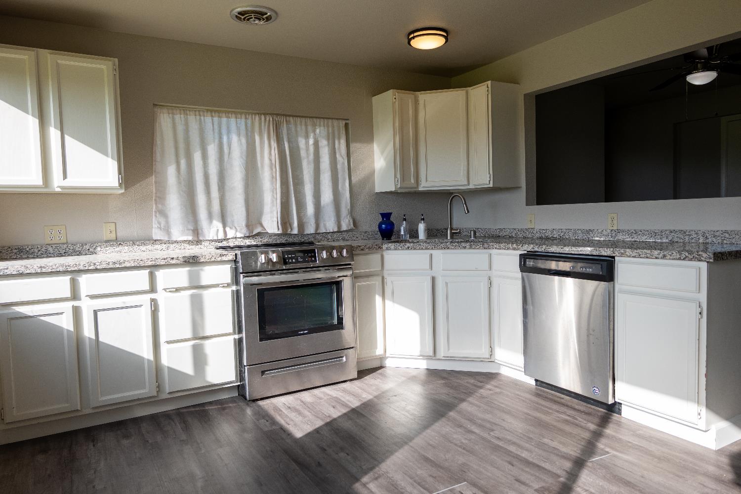 42560 Ranger Cir Way Coarsegold, CA 93614 - Photo 16 of 44 a kitchen with granite countertop a stove a sink and a microwave