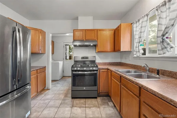 a kitchen with stainless steel appliances granite countertop a stove a sink and a refrigerator