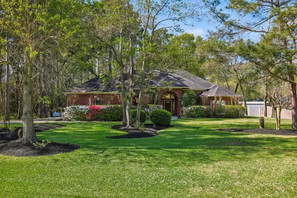 a front view of a house with a yard and trees