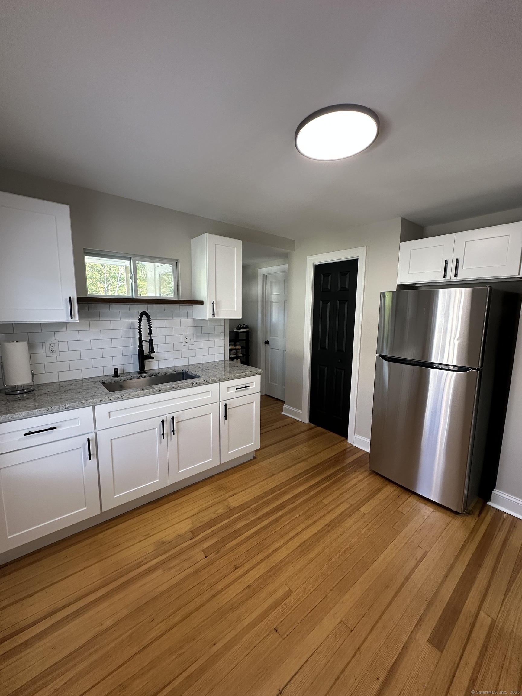 a large kitchen with white cabinets and stainless steel appliances