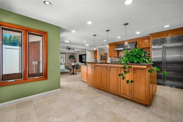 a kitchen with stainless steel appliances kitchen island granite countertop a refrigerator and a sink
