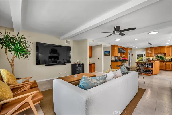 a living room with furniture kitchen view and a large window