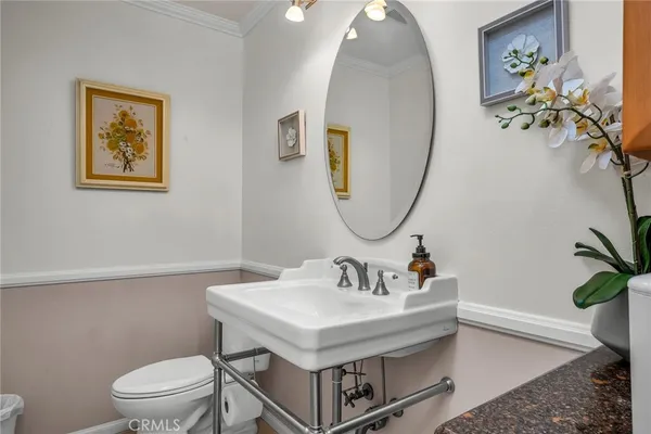 a bathroom with a sink toilet and a mirror
