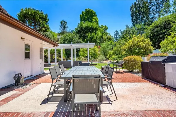 a view of a patio with a table chairs and a backyard