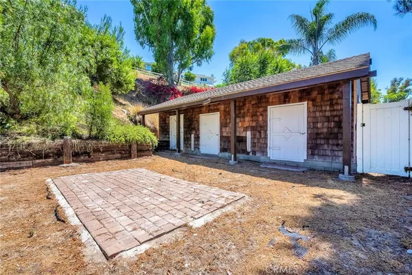 a view of house with backyard and trees around