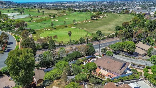 an aerial view of residential houses with outdoor space and trees