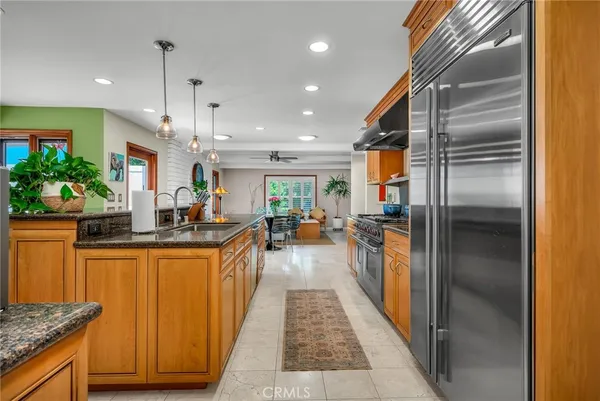 a kitchen with stainless steel appliances granite countertop a refrigerator a sink and a stove