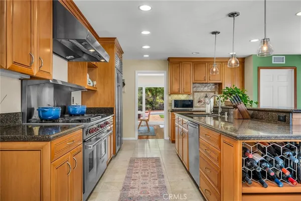 a kitchen with stainless steel appliances granite countertop a sink a stove and a refrigerator