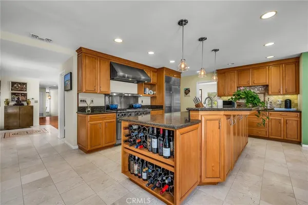 a kitchen with stainless steel appliances kitchen island granite countertop a stove a sink a refrigerator and a cabinets