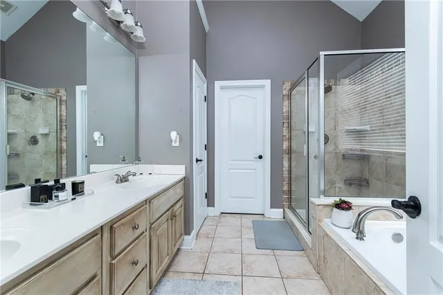 a spacious bathroom with a tub sink and mirror