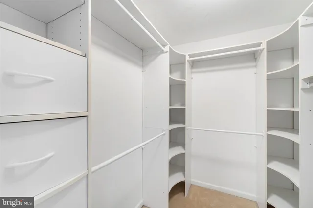 a view of an empty room with closet and wooden floor