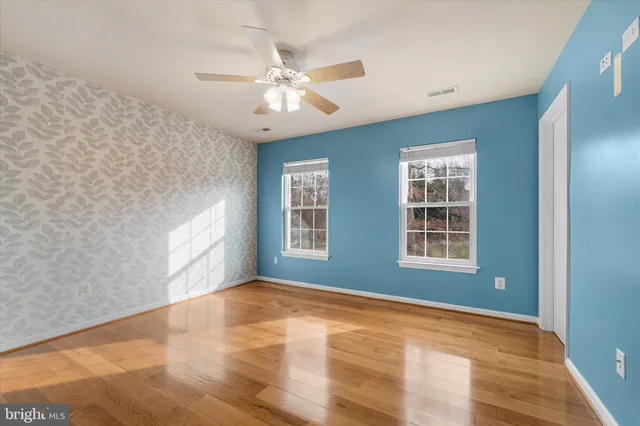 an empty room with a window and ceiling fan