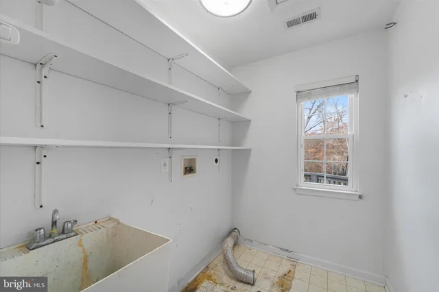 a view of an empty room with wooden floor and windows