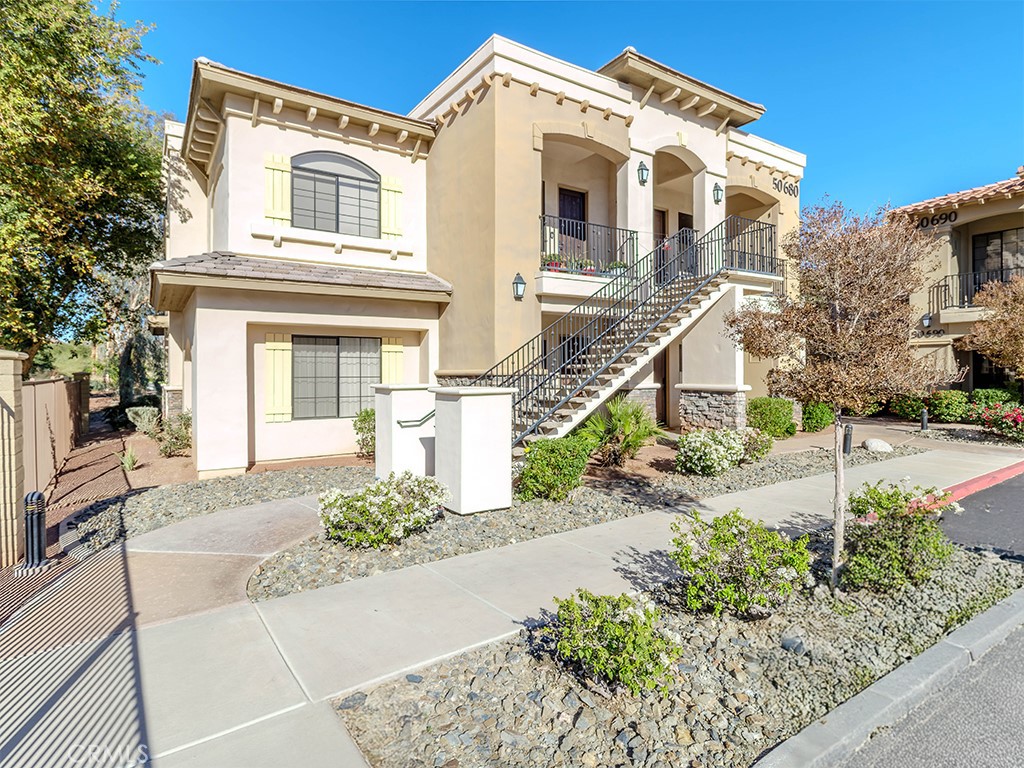 50680 Santa Rosa Plaza, Unit 8 La Quinta, CA 92253 - Photo 2 of 20 a view of a white house with large windows and a small yard