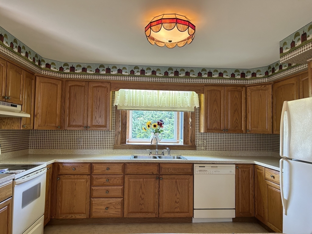 273 Main Street Acushnet, MA 02743 - Photo 18 of 37 a kitchen with stainless steel appliances granite countertop a stove a sink and a microwave