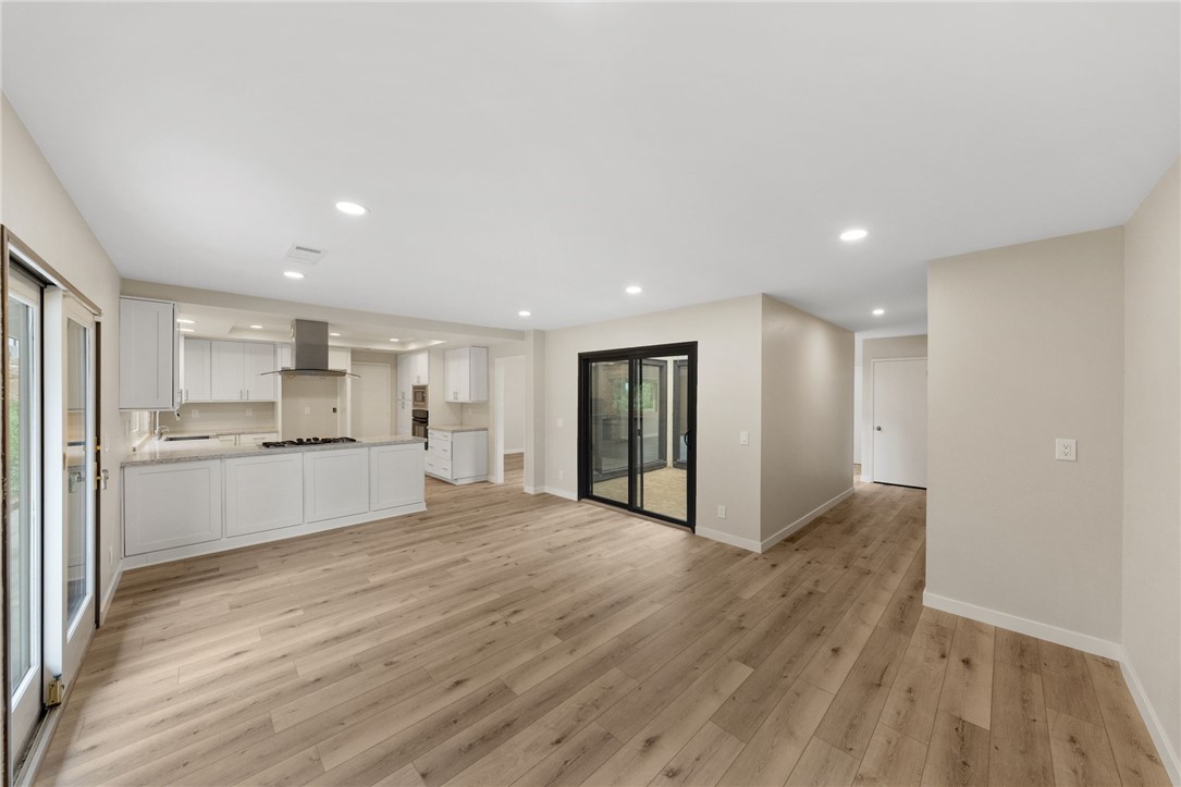 665 Norwynn Lane Fallbrook, CA 92028 - Photo 15 of 51 a large white kitchen with kitchen island a sink wooden floor and a refrigerator