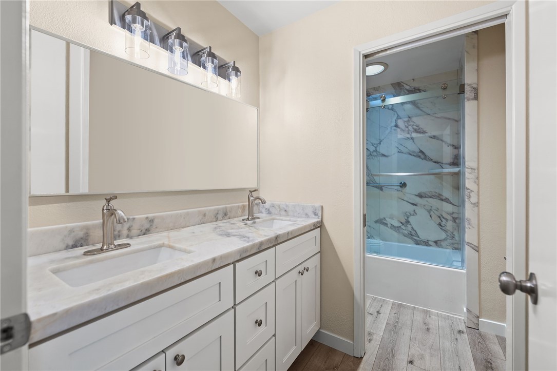 665 Norwynn Lane Fallbrook, CA 92028 - Photo 20 of 51 a bathroom with a granite countertop sink a mirror a vanity and shower