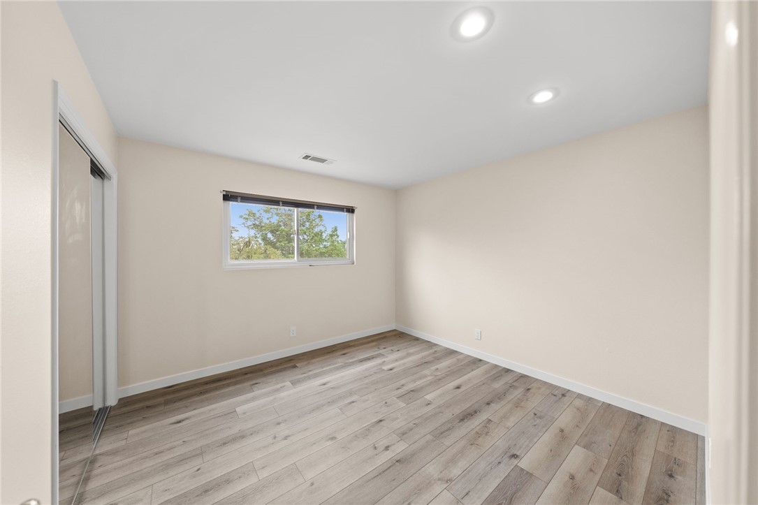 665 Norwynn Lane Fallbrook, CA 92028 - Photo 24 of 51 an empty room with wooden floor and windows