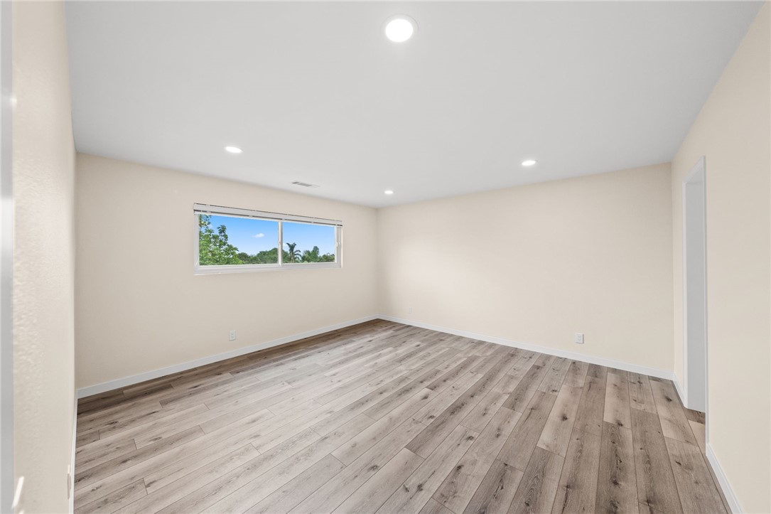 665 Norwynn Lane Fallbrook, CA 92028 - Photo 27 of 51 an empty room with wooden floor and windows