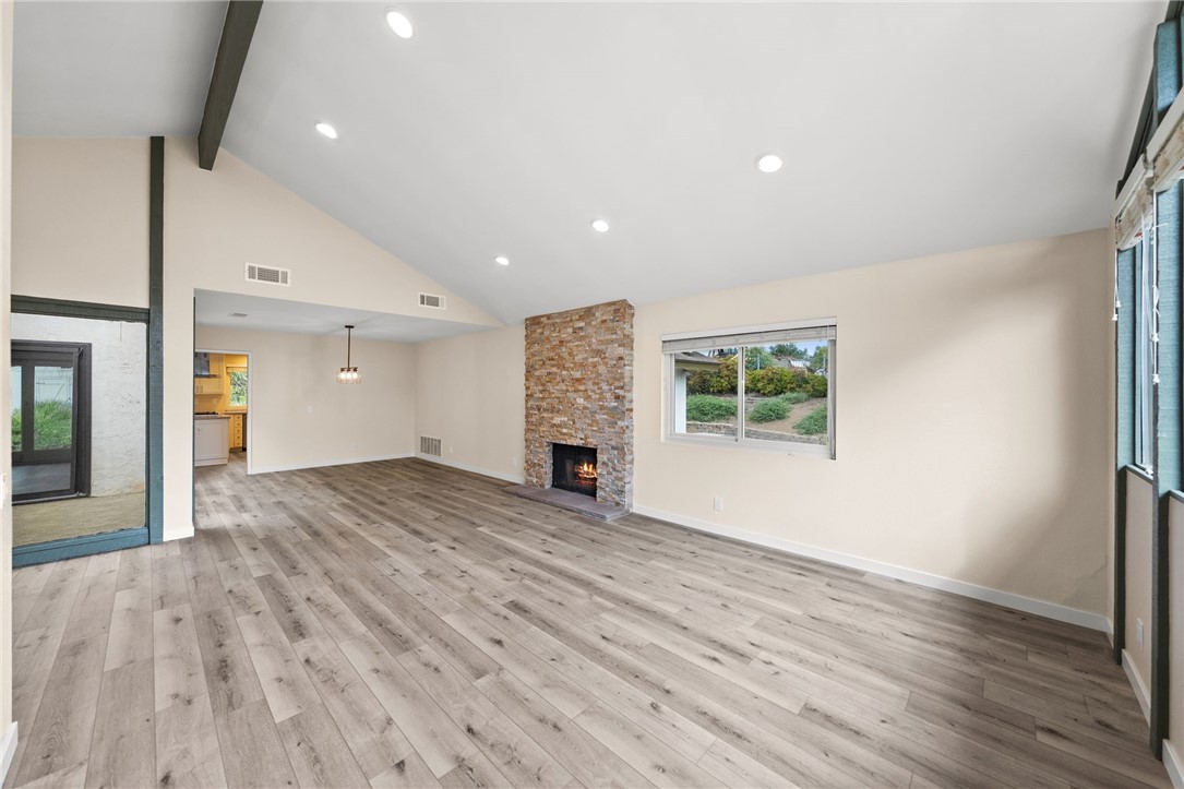 665 Norwynn Lane Fallbrook, CA 92028 - Photo 5 of 51 an empty room with wooden floor fireplace and windows