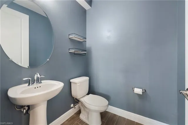 a bathroom with a sink a toilet and mirror