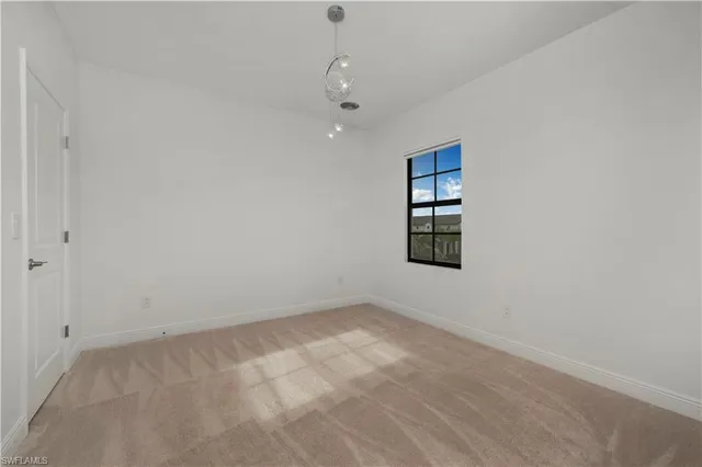 an empty room with windows and cabinet
