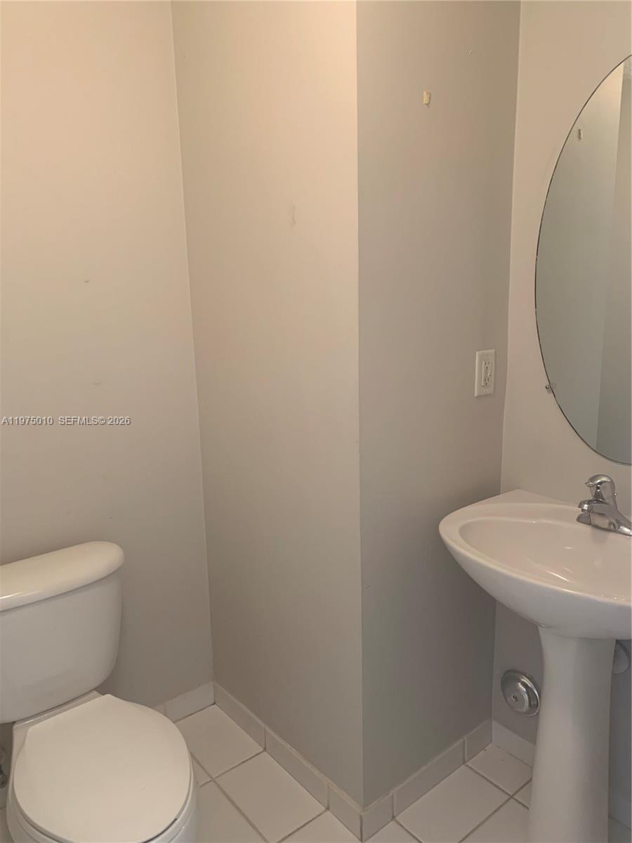 2211 Southeast 23rd Road, Unit 2211 Homestead, FL 33035 - Photo 20 of 39 a bathroom with a toilet sink and mirror