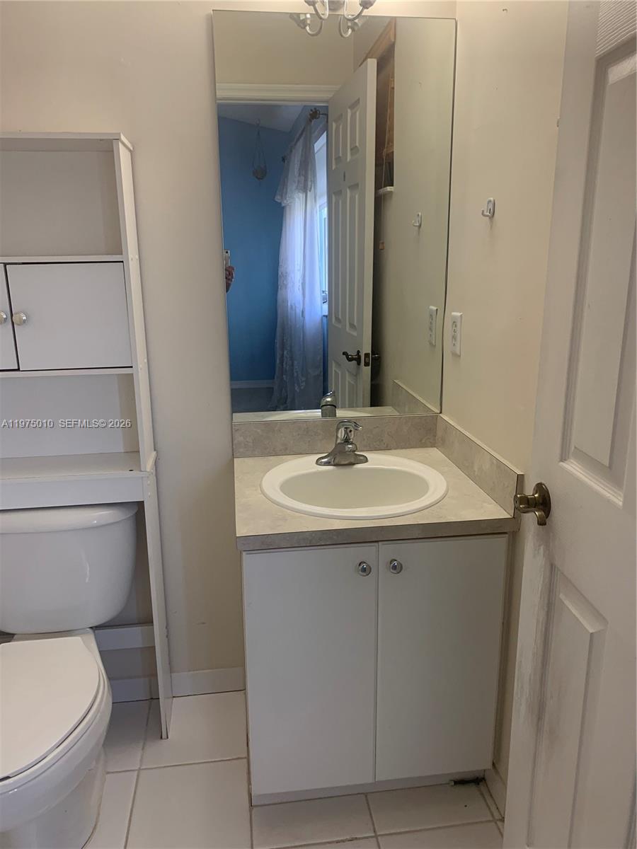 2211 Southeast 23rd Road, Unit 2211 Homestead, FL 33035 - Photo 21 of 39 a bathroom with a sink toilet and mirror