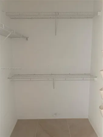 a view of road with a big yard and large trees