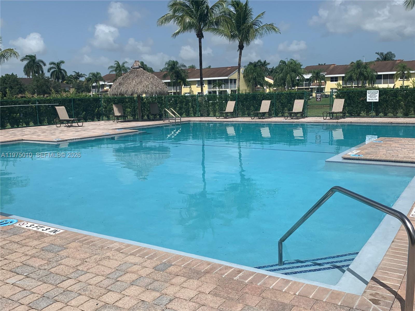 2211 Southeast 23rd Road, Unit 2211 Homestead, FL 33035 - Photo 29 of 39 a view of a swimming pool with an outdoor seating
